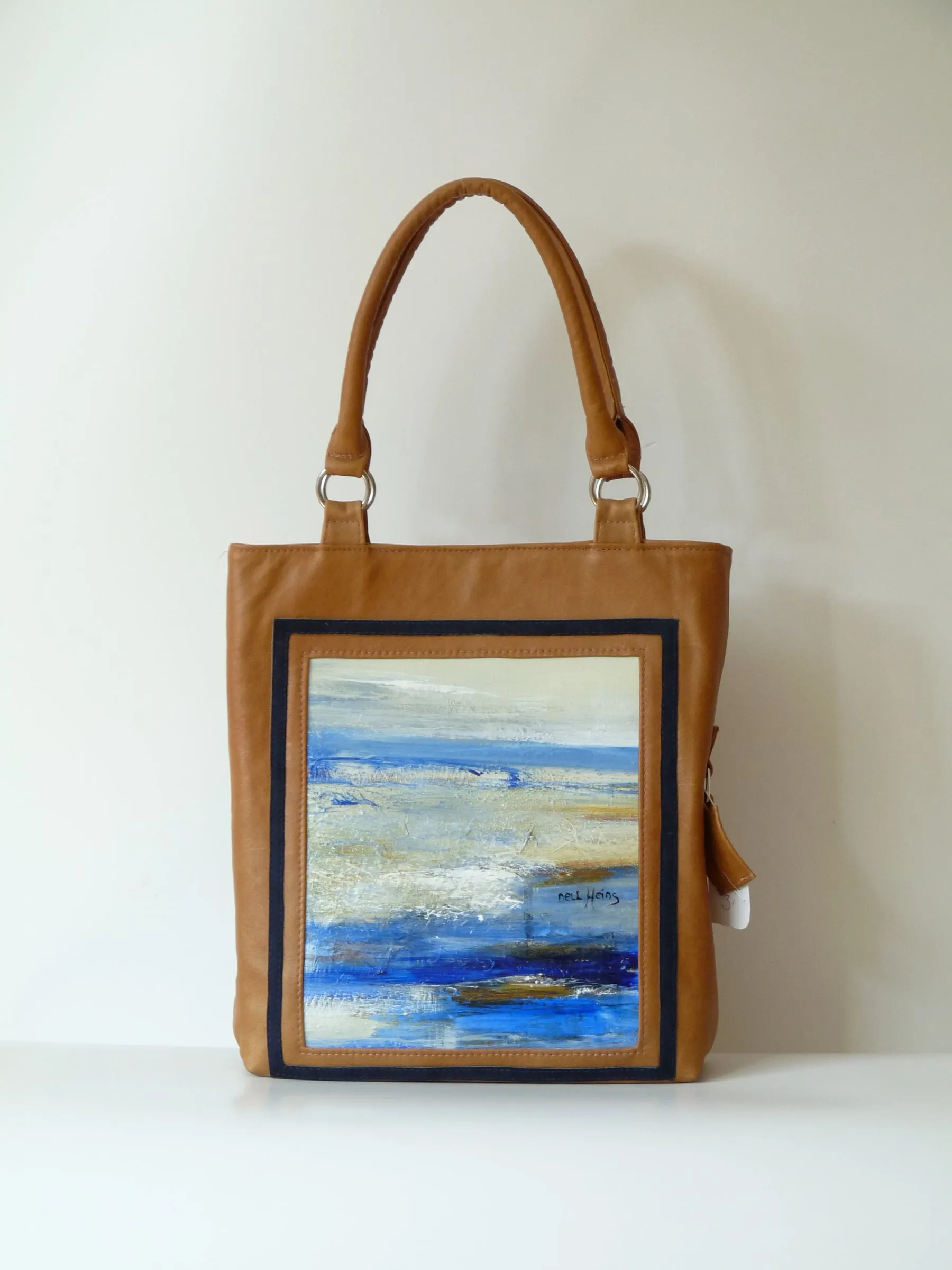 Cognacbruine shopper met een kunstwerk van zee en strand